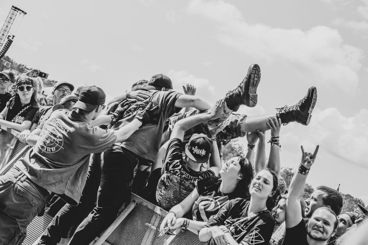 Schwarz-weiß: Crowdsurfer wird über die Köpfe der jubelnden Menge vor der Wacken-Bühne getragen